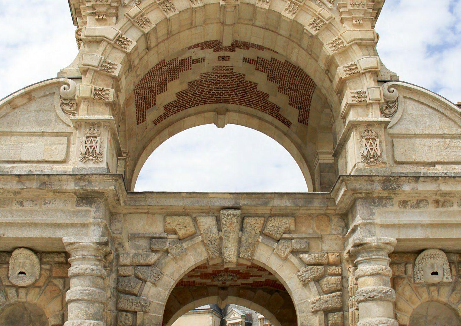 A stone archway at the Palace of Fontainebleau, her monogram carved above it
