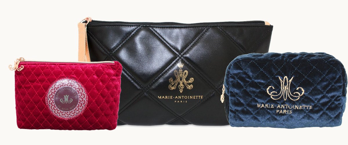 Three Marie-Antoinette cosmetic bags: quilted wine velvet, black quilted leather and navy velvet, each with the gold monogram