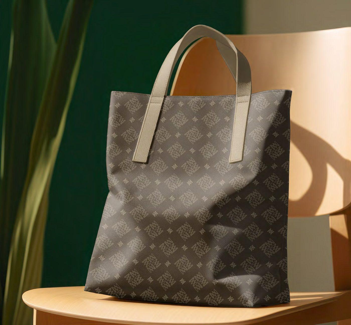 A Marie-Antoinette monogram tote bag on a chair against a deep green wall